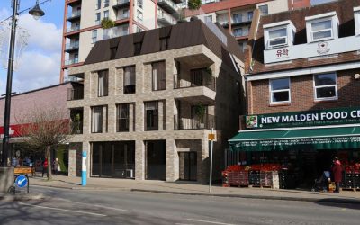 Contemporary mixed-use brick apartment building with modern balconies and retail frontage on a busy urban high street in London