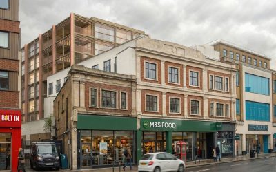 Contemporary mixed-use architecture blending historic brick façade with modern glass extension above a high street retail storefront in an urban setting