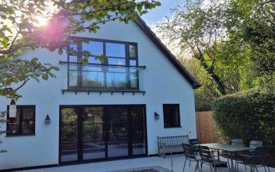 Contemporary white house with black‑framed glazing and garden patio, featured in Architecture Magazine
